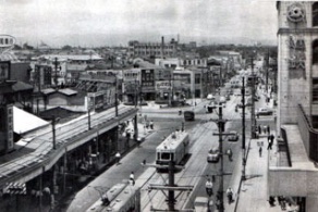 昭和３０〜４０年代頃の近鉄上本町交差点の画像です。当社はこの交差点を１本北西（上の画像では画像中央の交差点の少し左上）に入った場所に位置しています。昭和２８年にこの地で営業をはじめ、昭和４３年に現在の本社ビルが完成した頃はまだまわりに高いビルもなく近鉄百貨店の屋上から当社のビルが見えました。また昭和４４年までは大阪市電も走っていて各方面で活躍していました。左上画像は上六交差点を南側から撮影されたもので、左側は、現在『ハイハイタウン(1979年完成)』が建つ前の風景です。